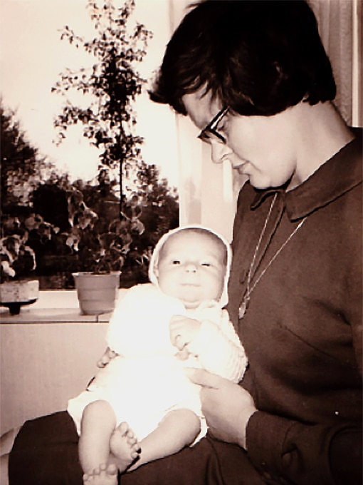 A woman holds a young baby.