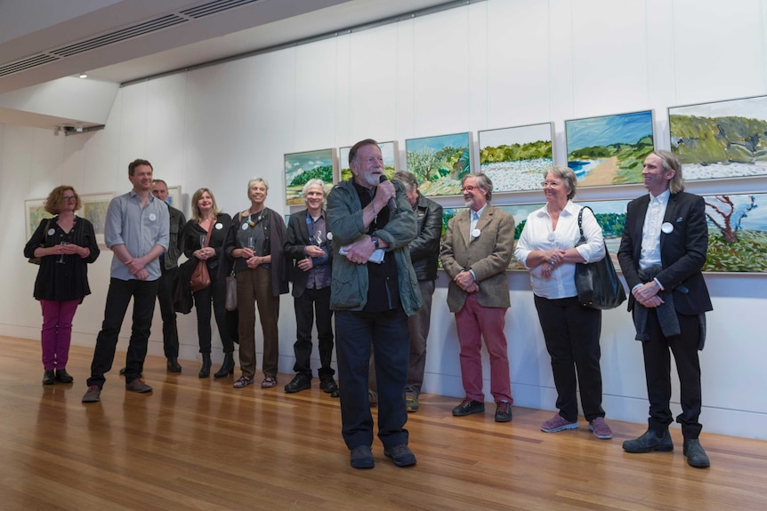 Actor Jack Thompson launched the 'Paint My Place' exhibition, with the artists behind him.