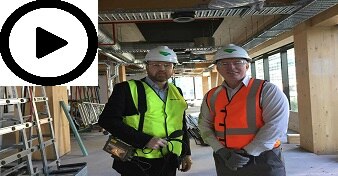 Two men in high-vis on a building construction site.