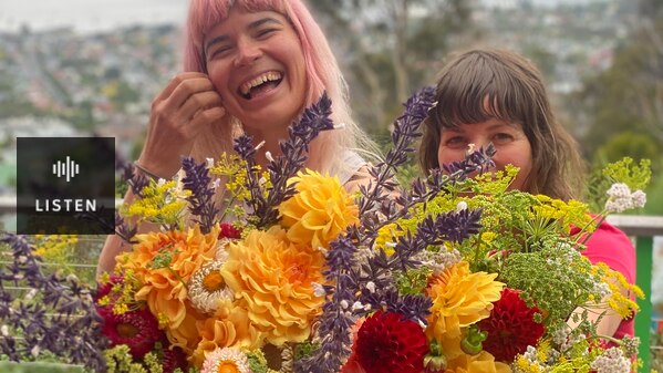 Two women with an enormous bunch of colourful flowers each. Has Audio.