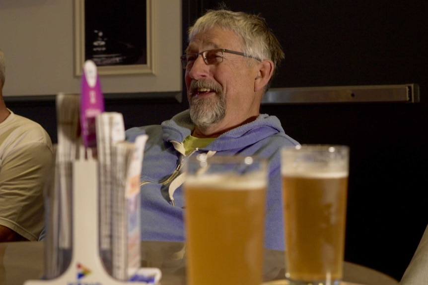 Men meet for a beer after a game of walking football.