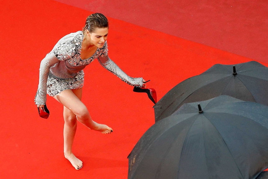 Actress Kristen Stewart takes off her heels at the red carpet at the Cannes Film Festival.