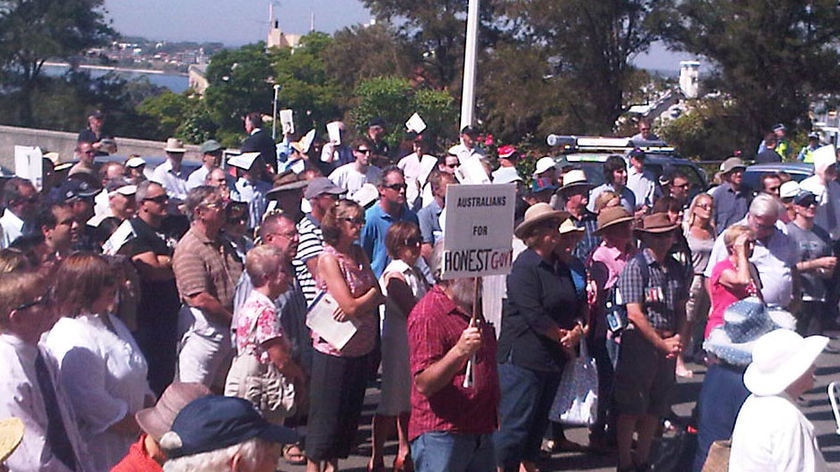 A crowd gathers outside parliament to protest against the carbon tax