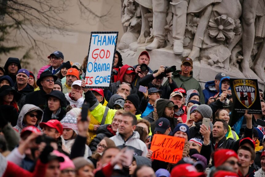 Protesters and onlookers gather during the inaugural parade.
