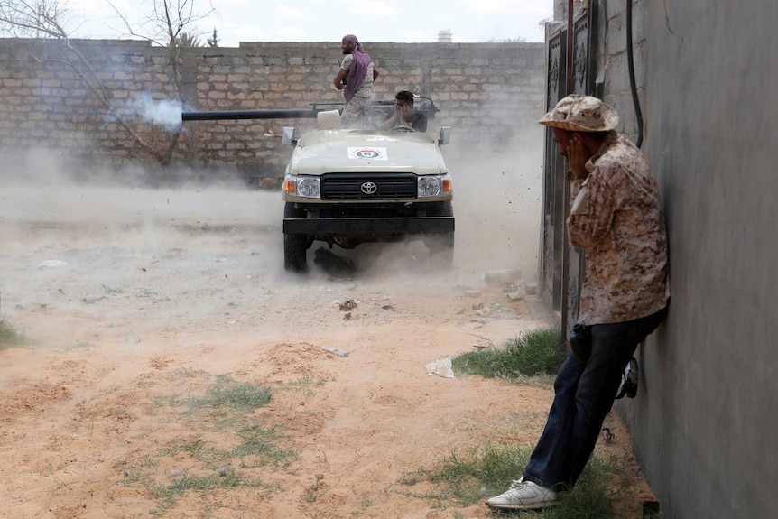 A fighter fires a 105 mm cannon from the back of a roofless vehicle.