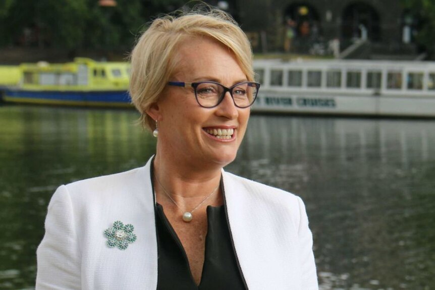 Sally Capp smiling as she stands by the Yarra River in Melbourne