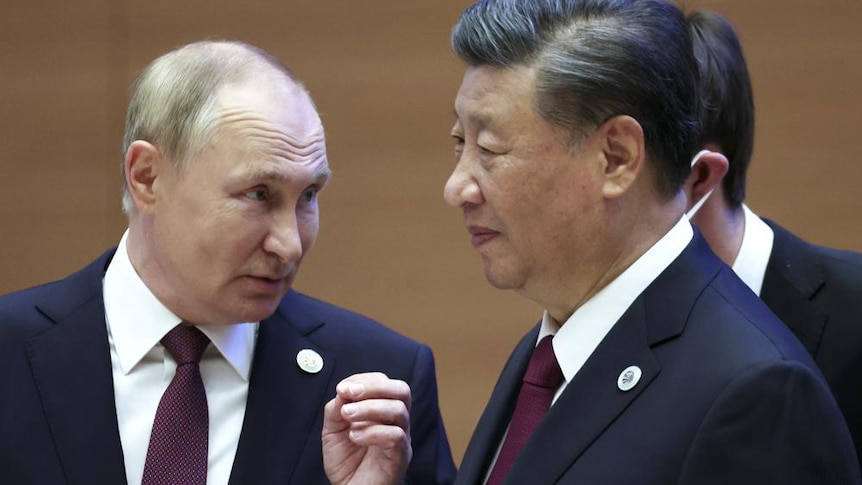 Russian President Vladimir Putin, left, gestures while speaking to Chinese President Xi Jinping 