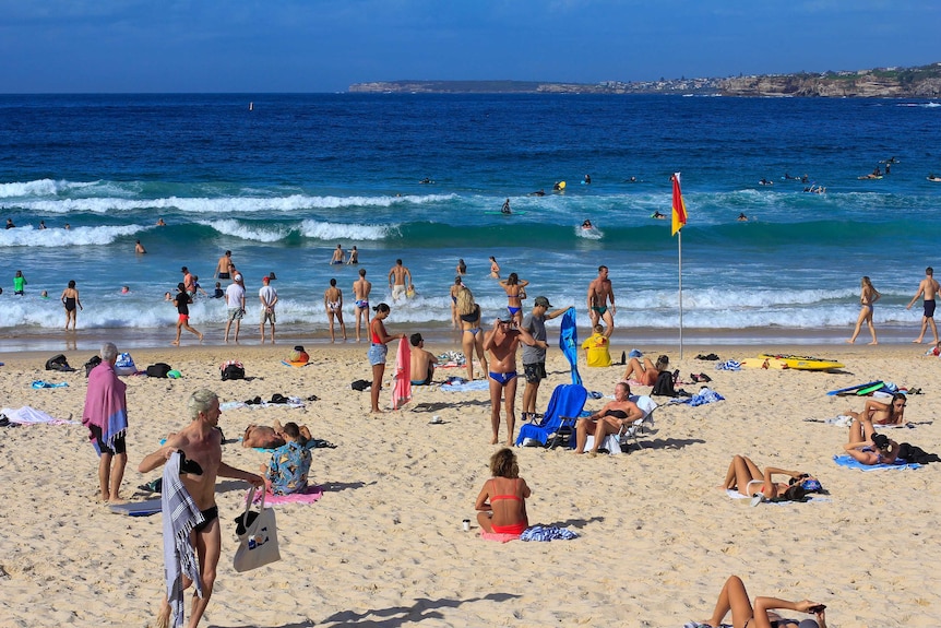 A large number of people go about their usual beach-going lives on Bondi Beach.