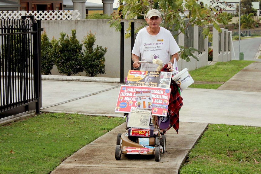 Claude Harvey pushes his lawnmower.