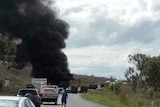 Fire and smoke billow from a truck after the crash north of Bajool in central Queensland.