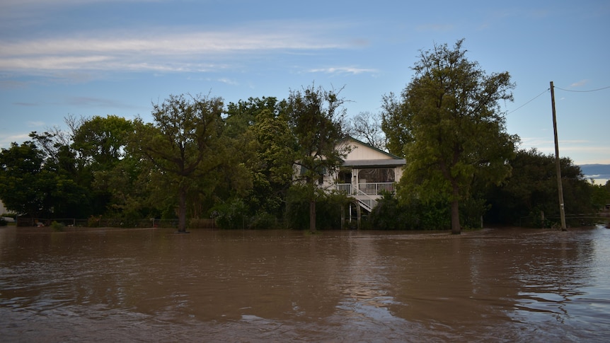 A home on stilts surrounded by a sea of water during floods
