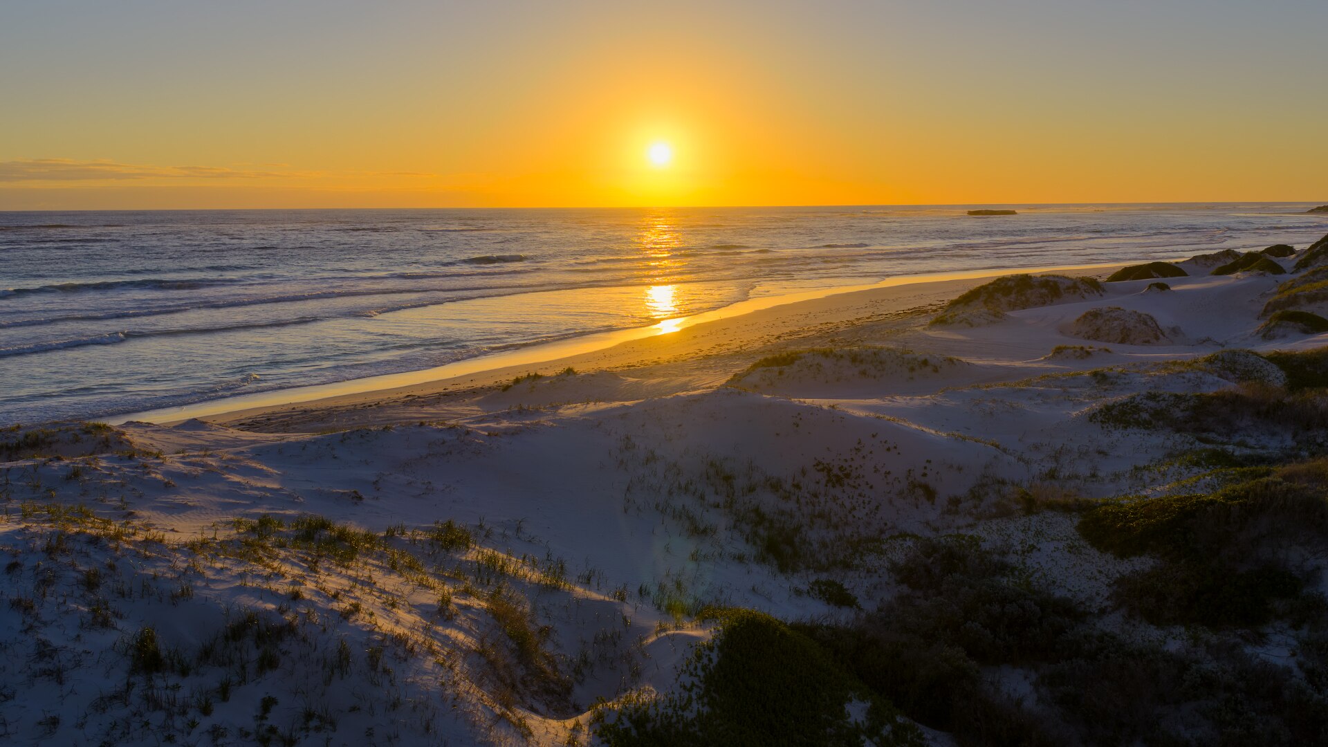 Puesta de sol sobre una playa.