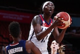 A USA player holds the ball in two hands as she drives to the basket at the Women's Basketball World Cup.
