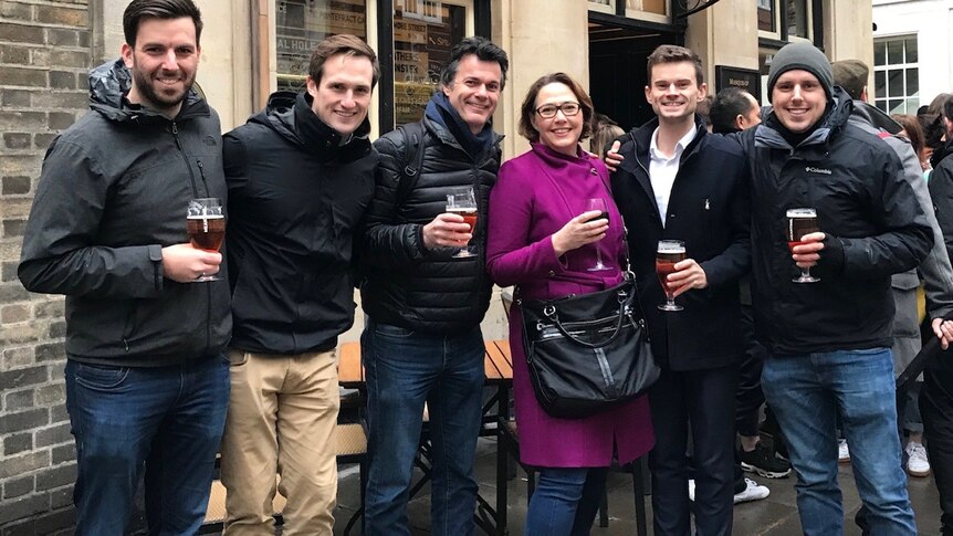 The ABC's London bureau holding beers in front of a local pub.