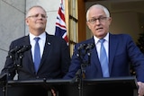 Scott Morrison and Malcolm Turnbull stand at two sets of microphones. Behind them is an Australian flag