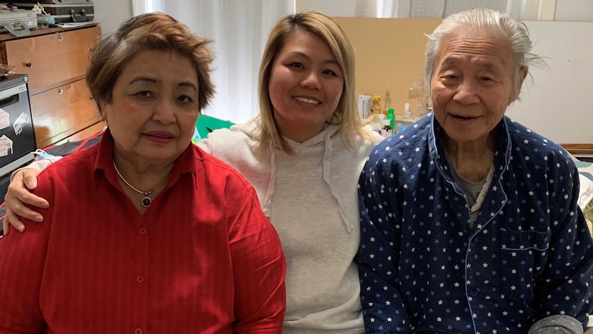 Three people sitting together and smiling at camera