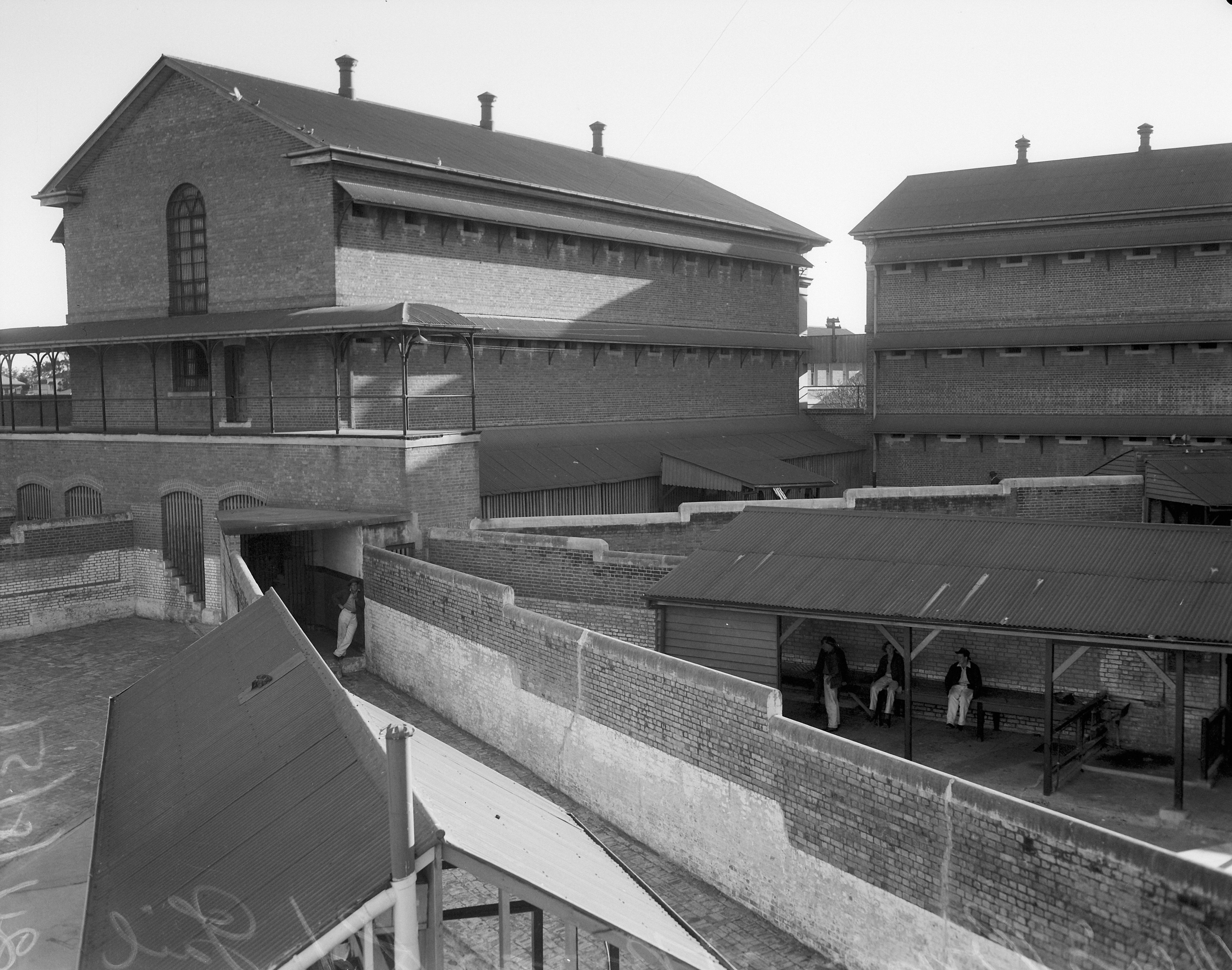 Black and white photograph of a prison building and yard.