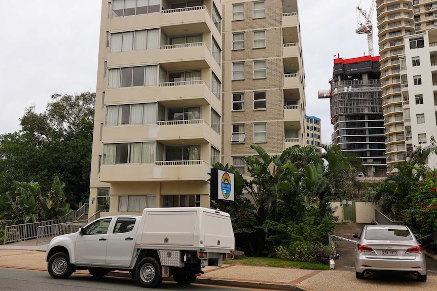 Apartment block with cars parked outside.