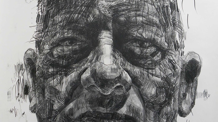A portrait of a man's face etched in black on a white surface.