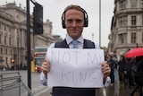 Paul stands with a not my king sign on a busy London footpath