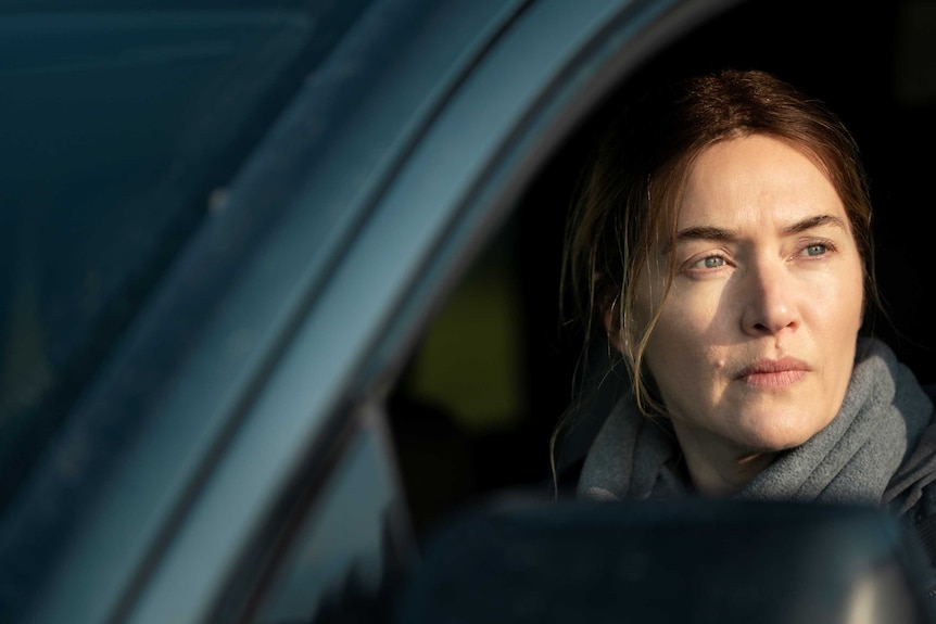 Kate Winslet stares out a car window in TV series Mare of Easttown