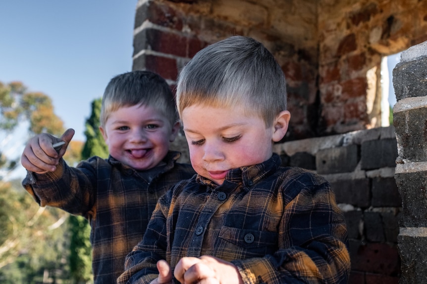 Identical twin toddlers play in chimney place