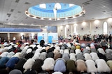 Men kneel in prayer inside a mosque.