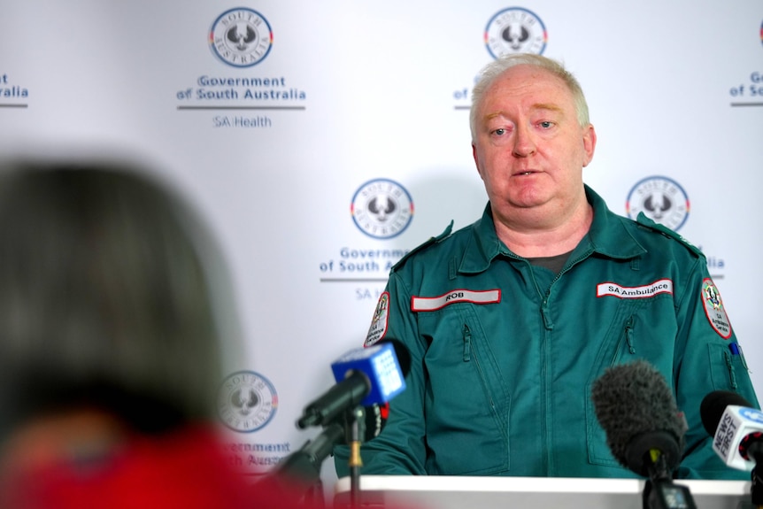A paramedic in uniform at a media conference.
