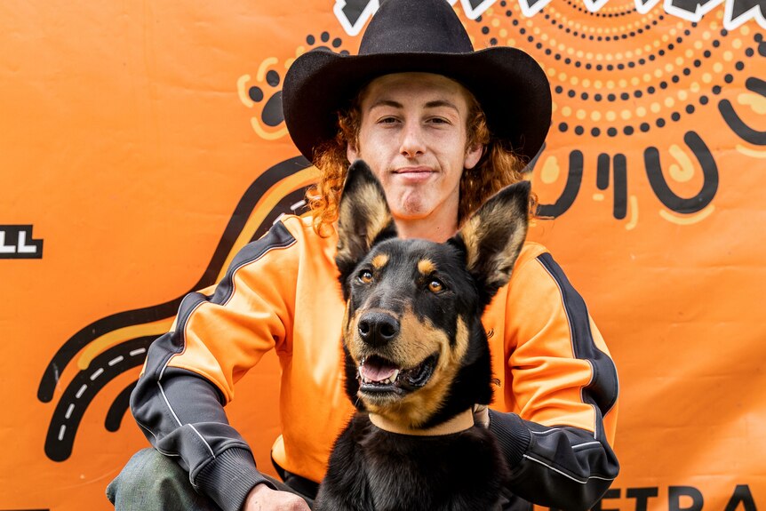 A boy in a cowboy hat with a dog