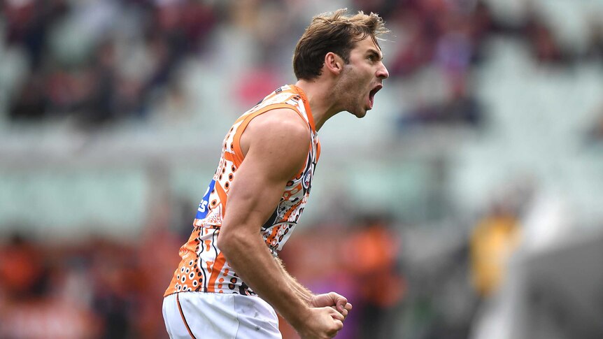 Jeremy Finlayson screams out as he pumps both fists in delight after kicking a goal.