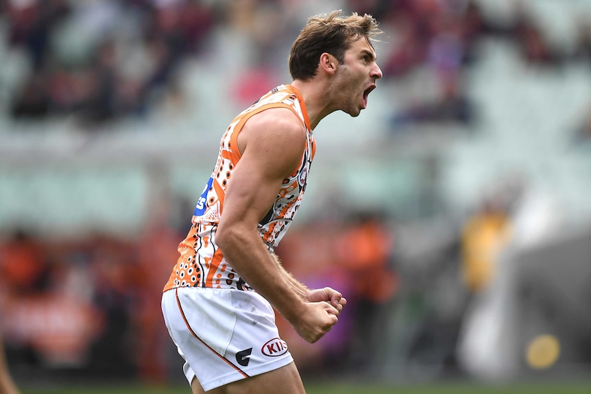Jeremy Finlayson screams out as he pumps both fists in delight after kicking a goal.