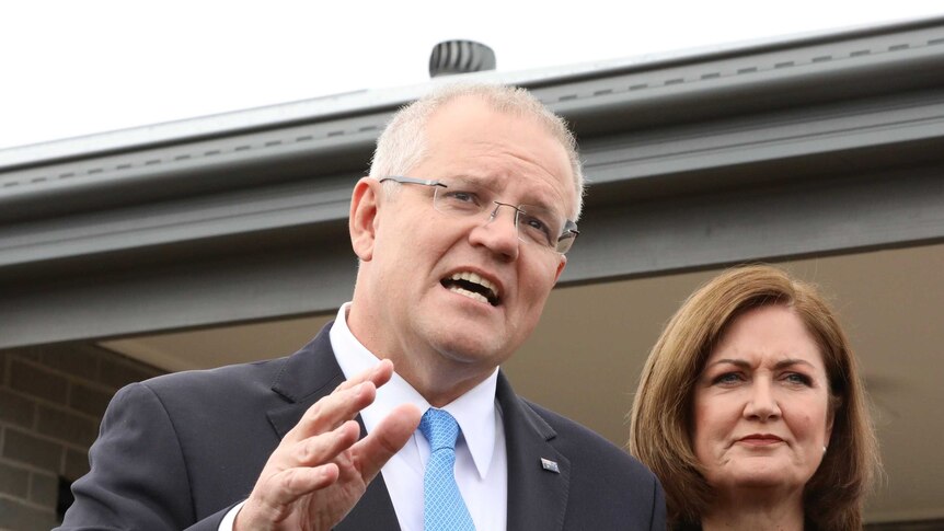 Scott Morrison and Sarah Henderson stand outside a newly build house answering questions