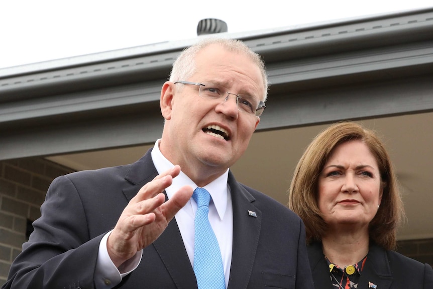 Scott Morrison and Sarah Henderson stand outside a newly build house answering questions