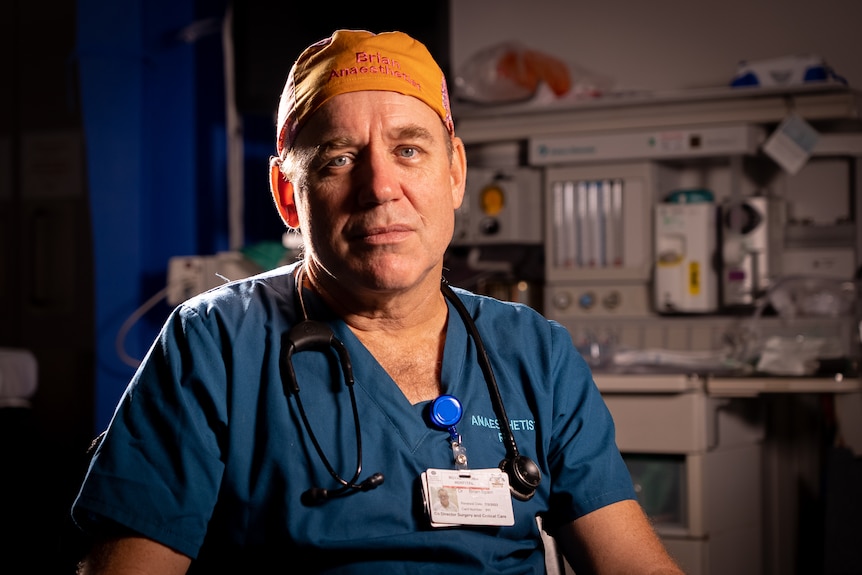 A male doctor wearing an orange helmet in a hospital trauma unit