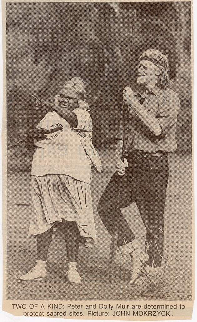 black and white picture of an Aboriginal woman and a white man holding a spear