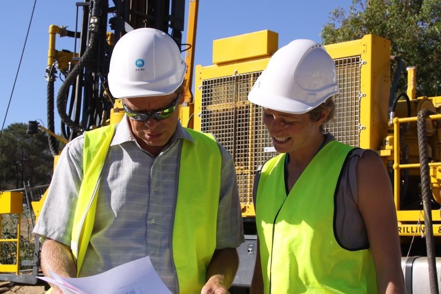 Professor Klaus Regenaur-Leib and field assistant standing in front of drill rig testing for geothermal energy