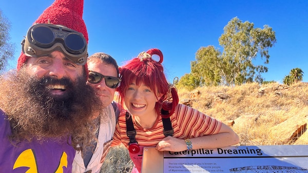 Costa the Garden Gnome, Scrapboy and Dirtgirl leaning on a sign in the Northern Territory.