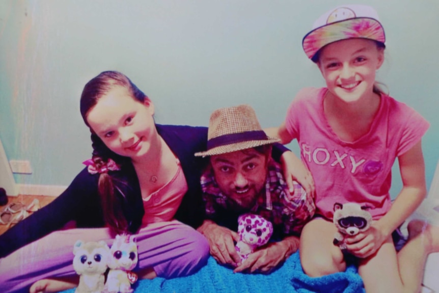 Roger Dunn poses with his two daughters.