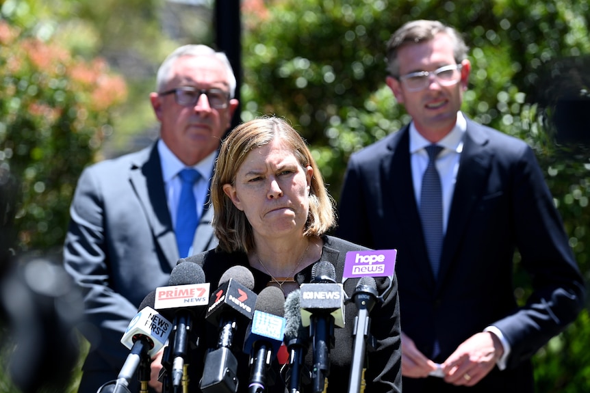 Three people in front of the media