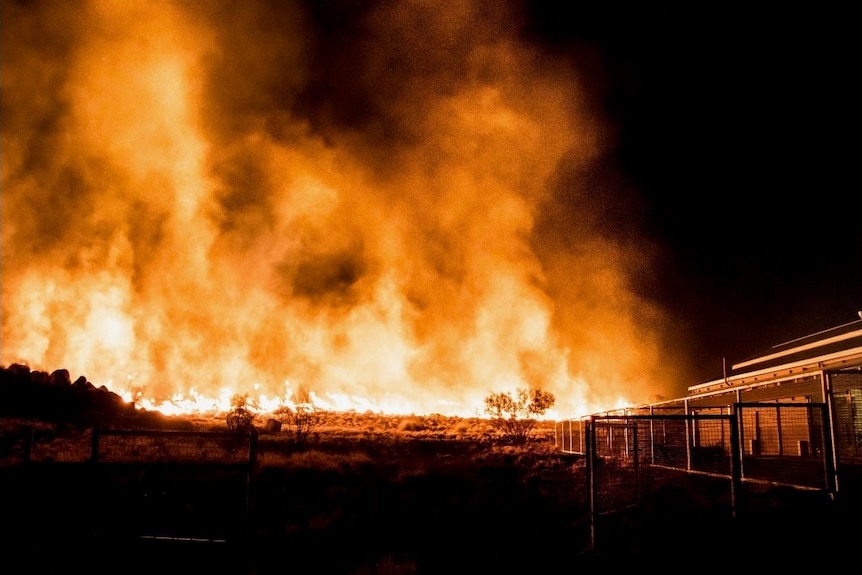 Billowing flames on a property at night 