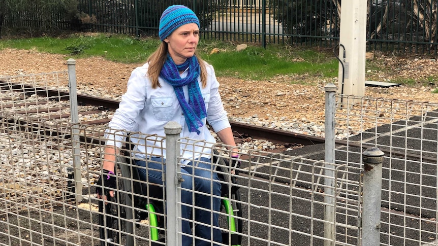 Adelaide rail user Jodie Pearce crosses the Tonsley line in a wheelchair.