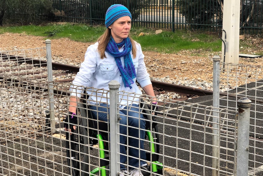 Adelaide rail user Jodie Pearce crosses the Tonsley line in a wheelchair.