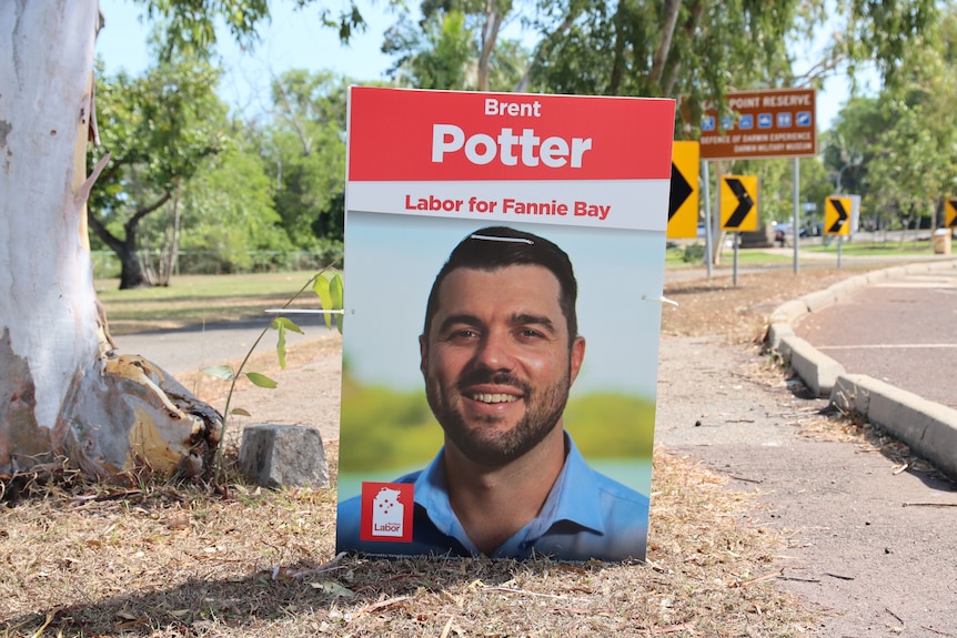 A corflute poster showing the face of Fannie Bay by-election Labor candidate Brent Potter, on the side of a road.
