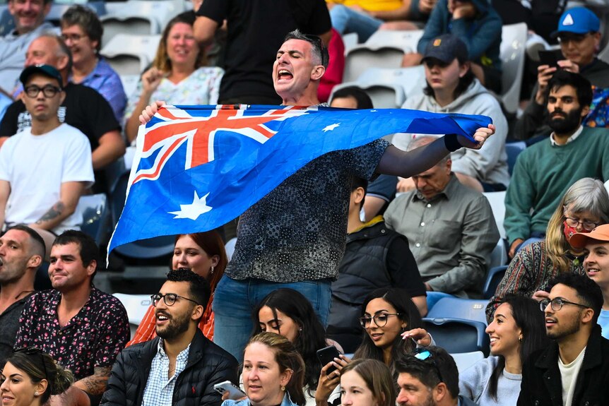 A spectator holds up an Australian flag at the Australian Open.