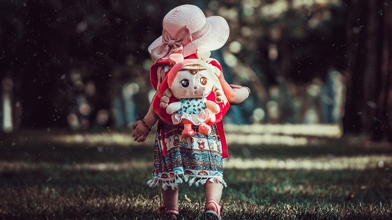 A toddler walks in a wooded area