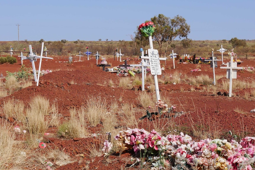 Grave markers in red soil in makeshift outback cemetery