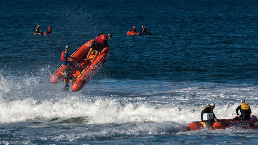an inflatable boat is launched high out of the water as it goes over a wave.