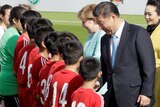 Xi Jinping is greeting a team of young Chinese footballers. 