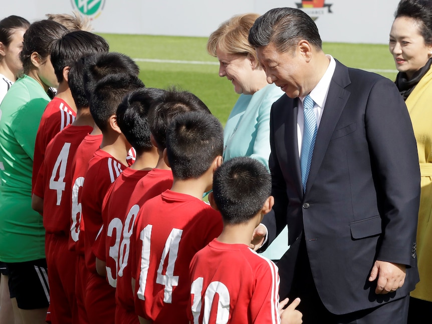 Xi Jinping is greeting a team of young Chinese footballers. 