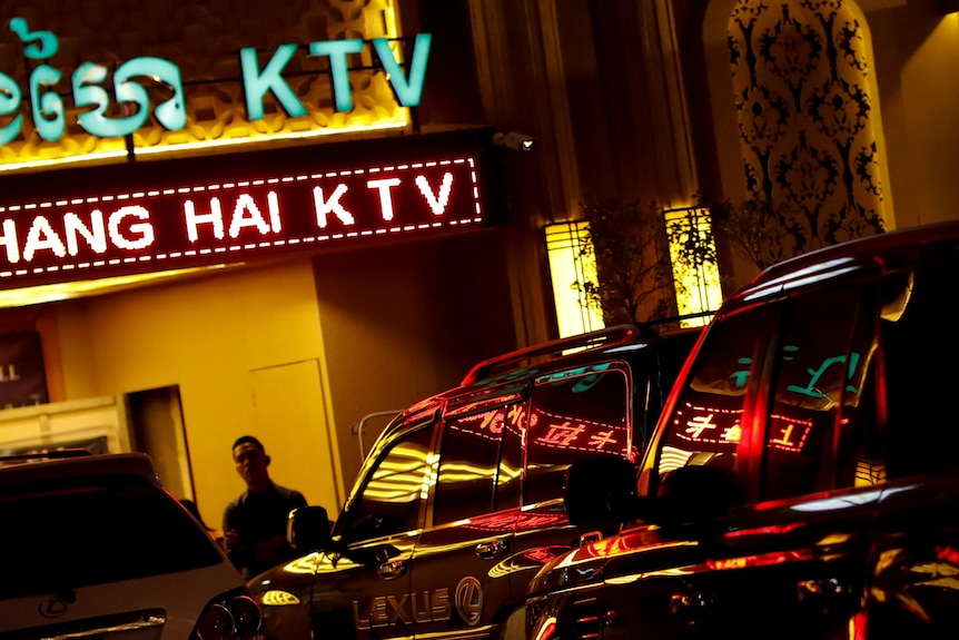 A man standing in front of a kareoke bar